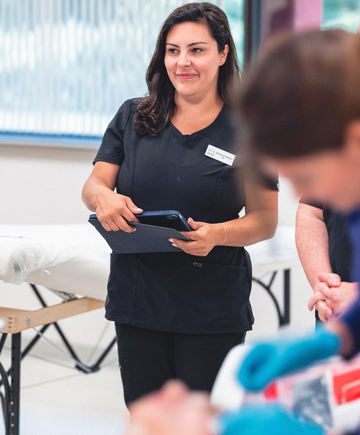 Medical professional reviewing notes in classroom setting.