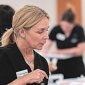 Skincare professionals performing facial treatment on client.