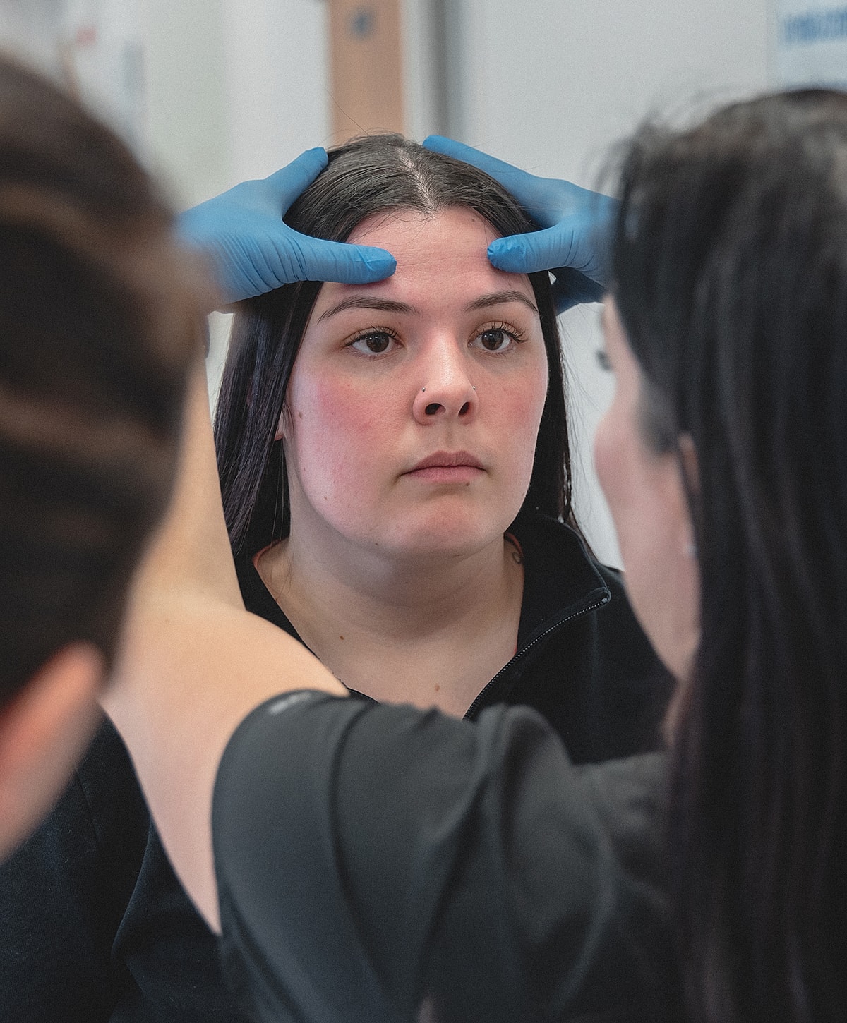 Patient receiving facial treatment and assessment.