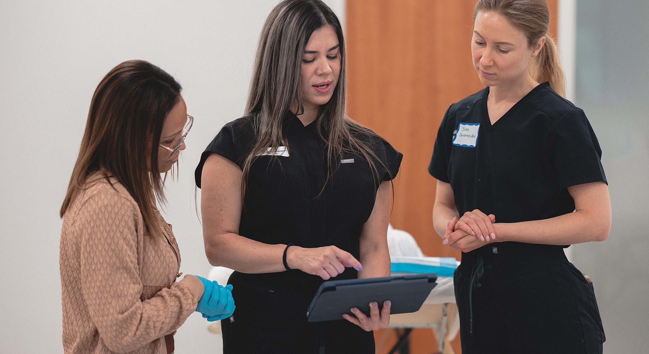 Medical professionals discussing patient care with tablet.